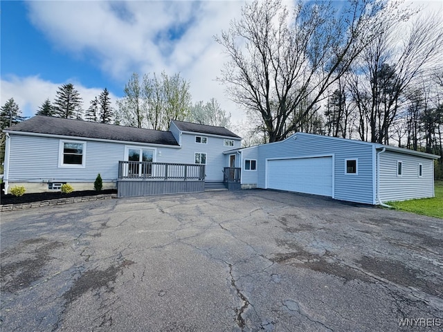view of front of home with an outbuilding, a deck, and a detached garage