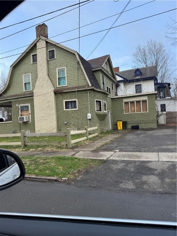 450 W Gray St, Elmira-City, NY 14905 - view of side of home with a gambrel roof, fence, and a chimney