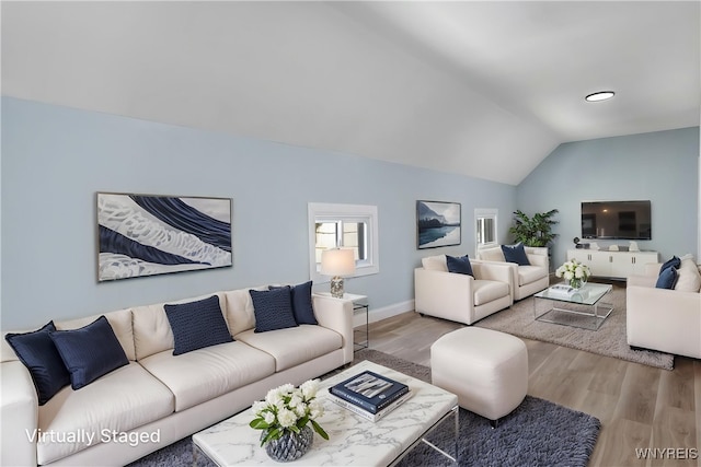 living area with vaulted ceiling and wood finished floors