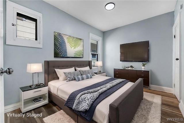 bedroom with baseboards and wood finished floors