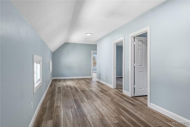 bonus room featuring baseboards, wood finished floors, and lofted ceiling