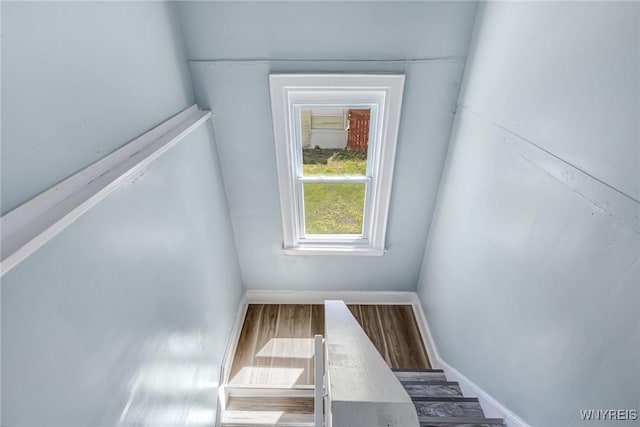 stairway featuring baseboards and wood finished floors