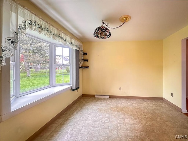 spare room featuring baseboards, a baseboard heating unit, and visible vents