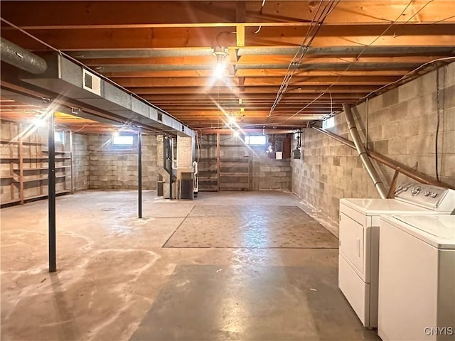 below grade area with plenty of natural light, heating unit, washing machine and dryer, and visible vents