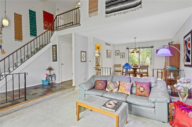 living room with visible vents, carpet flooring, and stairway