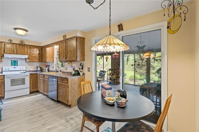 kitchen featuring stainless steel dishwasher, brown cabinetry, a sink, electric stove, and decorative light fixtures