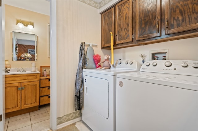 laundry area with cabinet space, light tile patterned floors, a sink, and washer and clothes dryer