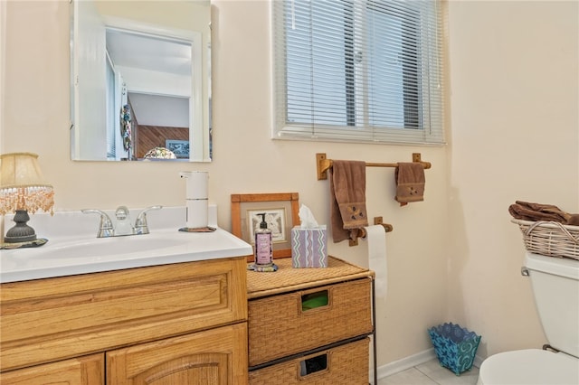 bathroom with toilet, baseboards, tile patterned flooring, and vanity