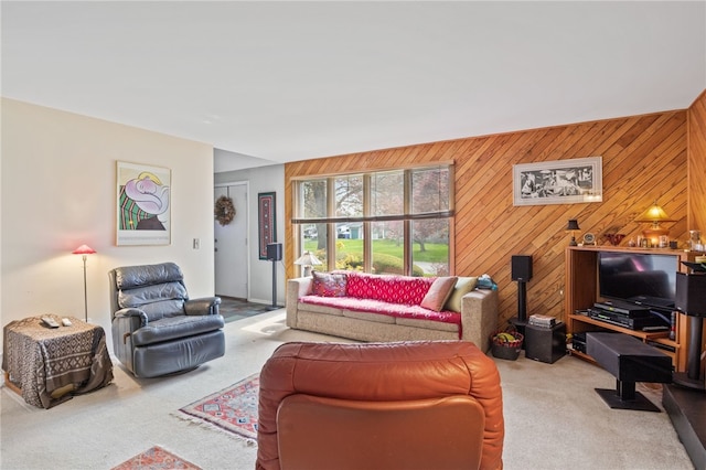 carpeted living area with wood walls