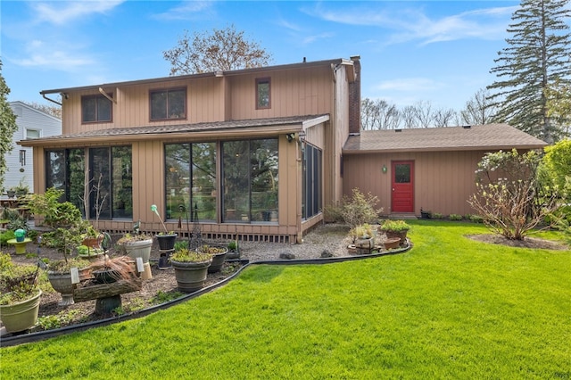 back of property featuring a yard, a chimney, a sunroom, and a vegetable garden