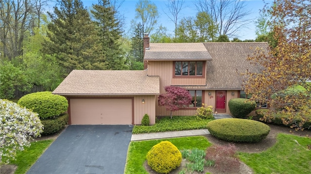 view of front of house with a garage, aphalt driveway, a chimney, and a shingled roof