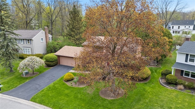 view of front of house with a residential view, a garage, and a front yard