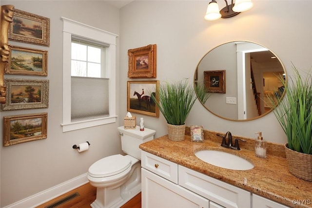 bathroom with vanity, toilet, wood finished floors, and visible vents