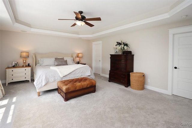 bedroom featuring a raised ceiling, baseboards, a ceiling fan, and light colored carpet