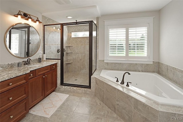 bathroom featuring a whirlpool tub, a shower stall, a healthy amount of sunlight, and vanity