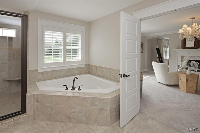 full bathroom with tiled bath, tile patterned floors, and an inviting chandelier