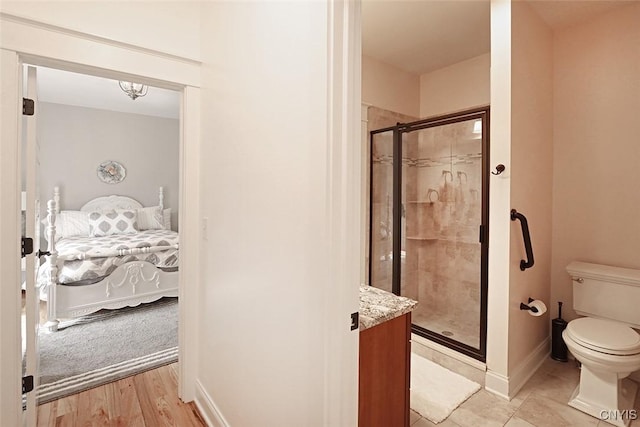 full bathroom featuring baseboards, ensuite bath, toilet, and a shower stall