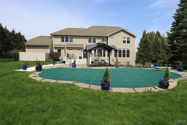 back of house featuring a gazebo, fence, a yard, and a fenced in pool