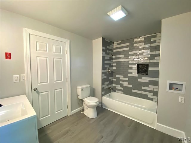 full bathroom featuring vanity, toilet, baseboards, wood finished floors, and  shower combination