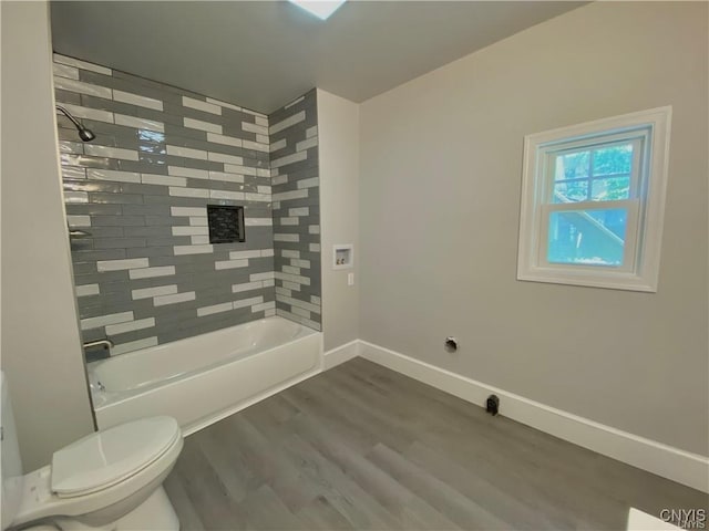 full bathroom featuring toilet, baseboards, wood finished floors, and bathtub / shower combination