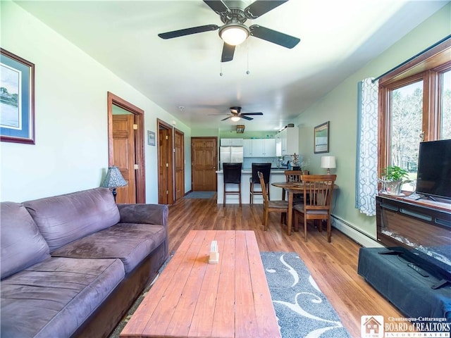 5585 Eke Rd, Harmony, NY 14710 - living room with a ceiling fan, a baseboard heating unit, and light wood-style flooring