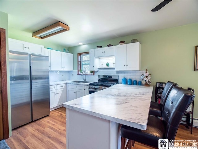 5585 Eke Rd, Harmony, NY 14710 - kitchen with a sink, light countertops, a peninsula, stainless steel appliances, and white cabinetry
