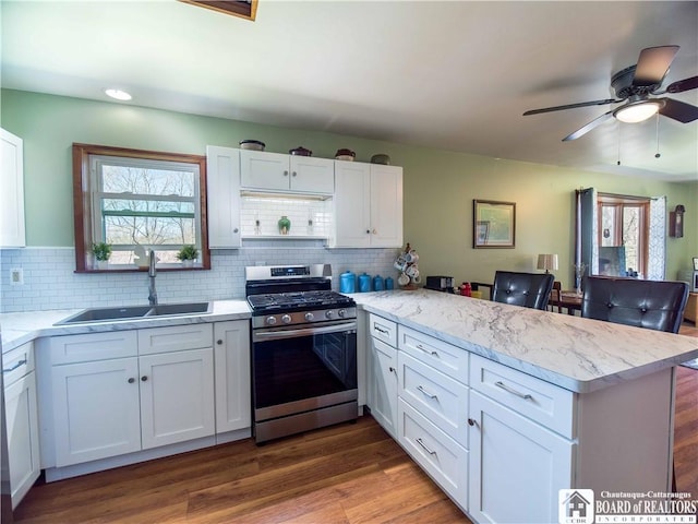 5585 Eke Rd, Harmony, NY 14710 - kitchen featuring stainless steel range with gas stovetop, a peninsula, white cabinets, and a sink