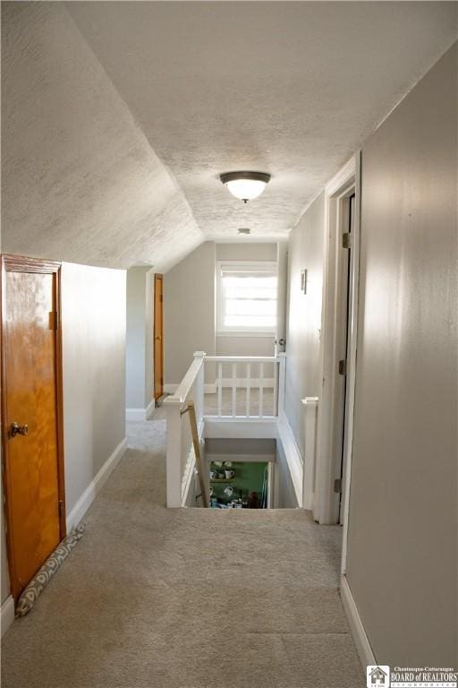 17 Howard St, Carroll, NY 14738 - hall with lofted ceiling, baseboards, a textured ceiling, carpet flooring, and an upstairs landing