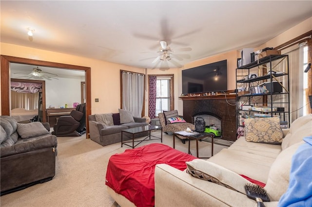 carpeted living area featuring a brick fireplace and ceiling fan