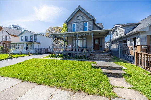 view of front of home featuring a porch, fence, and a front yard