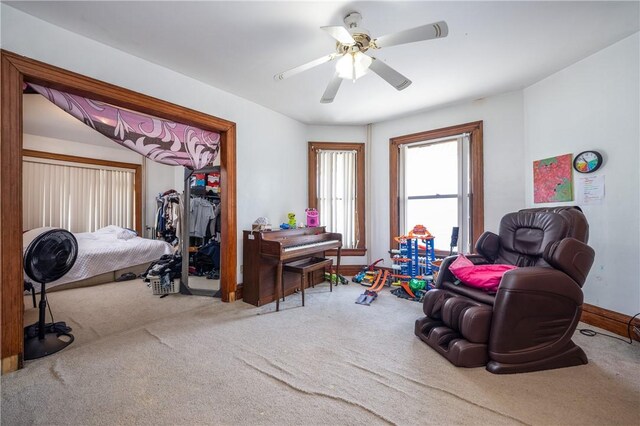 interior space with baseboards, a ceiling fan, and carpet flooring
