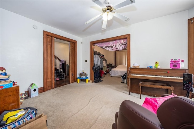 carpeted living area featuring ceiling fan
