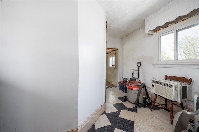 hall with baseboards and a wall mounted air conditioner