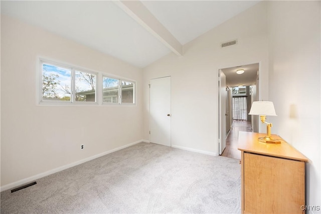 unfurnished bedroom featuring light carpet, lofted ceiling with beams, and visible vents