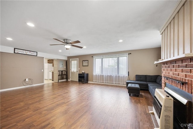 living room with ceiling fan, recessed lighting, baseboards, heating unit, and wood finished floors