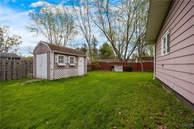 view of yard featuring an outdoor structure, a fenced backyard, and a shed