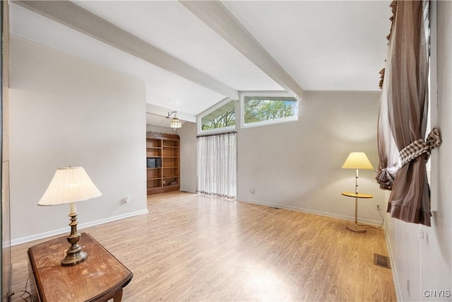 living area with baseboards, lofted ceiling with beams, wood finished floors, and visible vents
