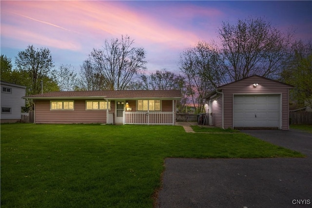 ranch-style house with a garage, a front lawn, aphalt driveway, covered porch, and an outbuilding