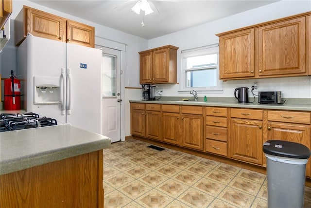 24 Sherman St, Union, NY 13790 - kitchen with ceiling fan, brown cabinetry, white refrigerator with ice dispenser, a sink, and light countertops
