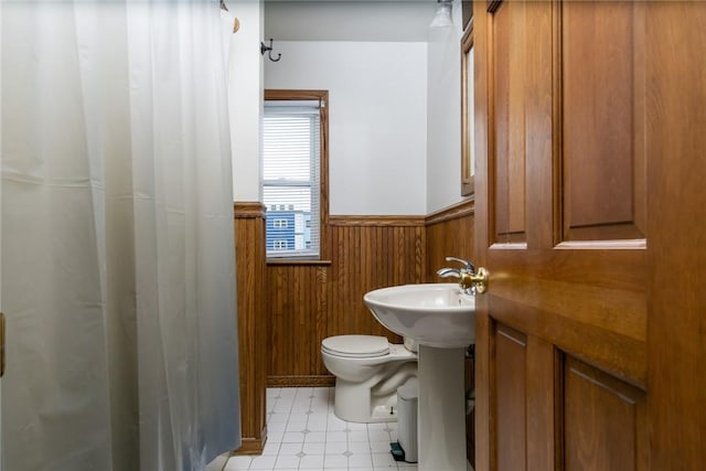 24 Sherman St, Union, NY 13790 - full bathroom featuring wainscoting, toilet, wooden walls, tile patterned floors, and a shower with curtain