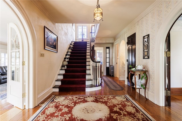 43 S Main St, Elba, NY 14058 - foyer featuring hardwood / wood-style flooring, stairs, crown molding, arched walkways, and wallpapered walls