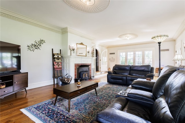 43 S Main St, Elba, NY 14058 - living room featuring ornamental molding, wood finished floors, a wood stove, baseboards, and arched walkways