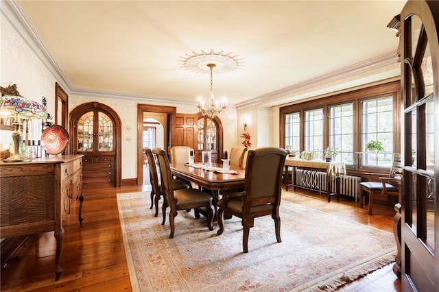 43 S Main St, Elba, NY 14058 - dining area featuring crown molding, a chandelier, wood-type flooring, and radiator heating unit