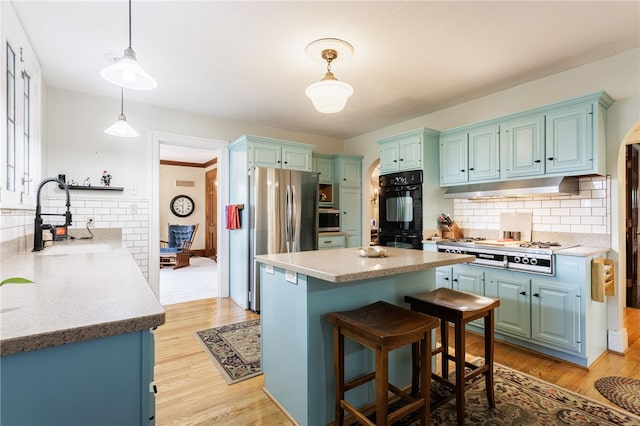 43 S Main St, Elba, NY 14058 - kitchen featuring under cabinet range hood, a sink, stainless steel appliances, backsplash, and a kitchen island