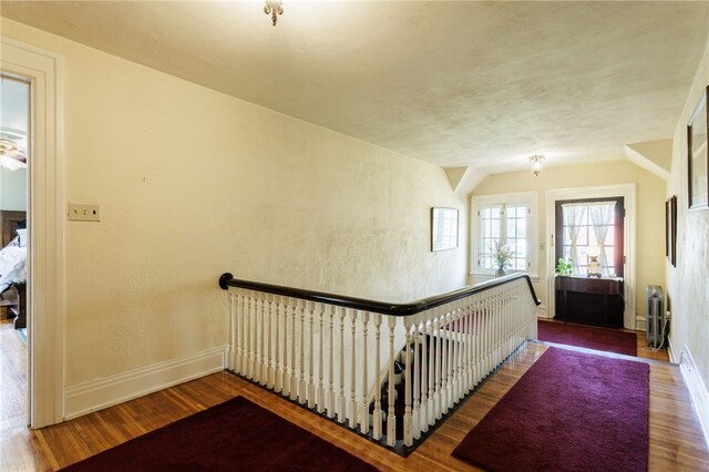 43 S Main St, Elba, NY 14058 - hallway featuring wood finished floors, radiator, an upstairs landing, baseboards, and a textured wall