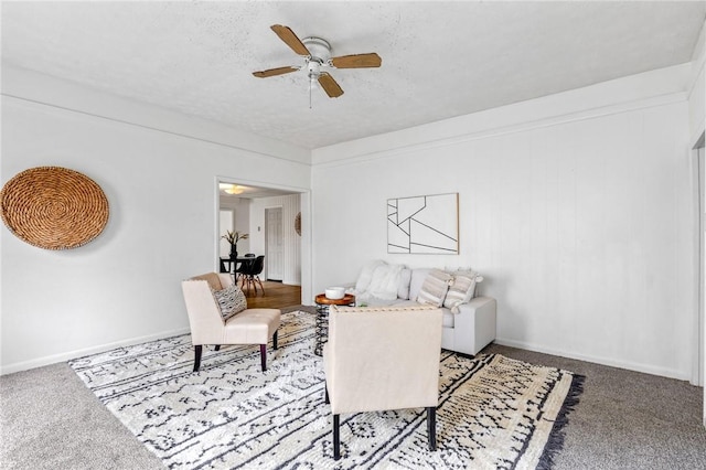 carpeted living room featuring ceiling fan and baseboards