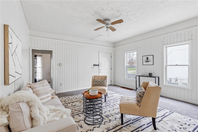 living area featuring a ceiling fan and light colored carpet