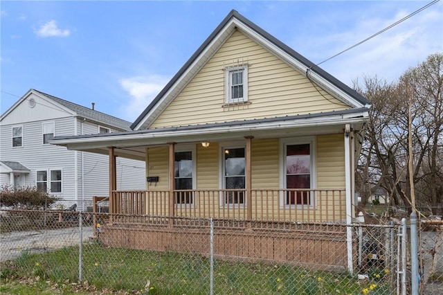 view of front of property featuring covered porch and a fenced front yard