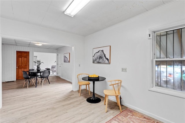 interior space featuring baseboards, ornamental molding, and light wood-style flooring