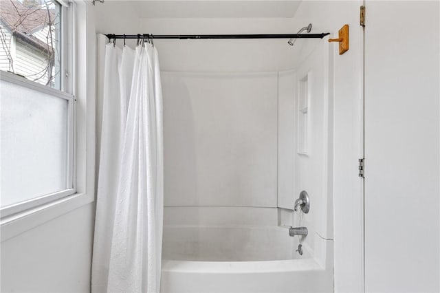 bathroom with shower / bathtub combination with curtain and a wealth of natural light
